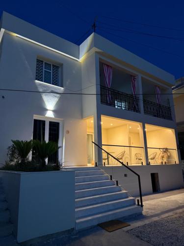 a white house with stairs in front at night at Casa del Mar in Vlorë