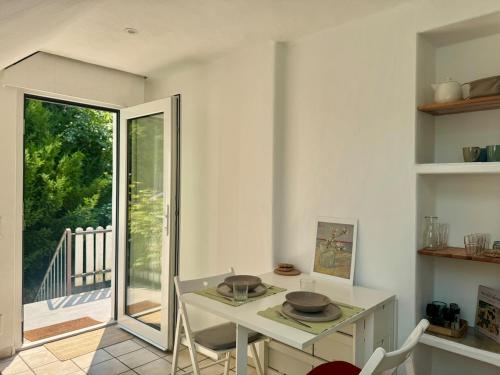 Una cocina con mesa y sillas y una puerta corrediza de vidrio. en Kleine Oase im Grünen!, en Heiligenhaus