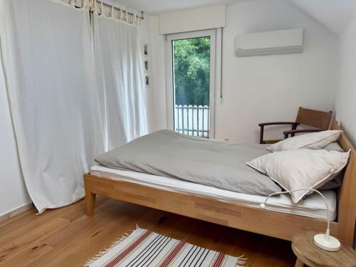 Una habitación blanca con una cama y una ventana en Kleine Oase im Grünen!, en Heiligenhaus