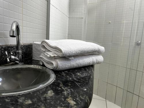 uma casa de banho com lavatório e toalhas num balcão em Apartamento, piscina, natureza e sossego em Macapá