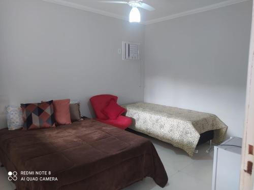 un dormitorio con una cama y un sofá en Suíte praia dos Anjos, en Arraial do Cabo