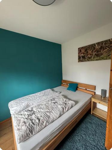 - une chambre dotée d'un lit avec un mur vert dans l'établissement Ferienwohnung Fuchsbau, à Weibersbrunn