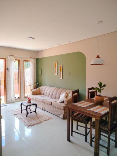 ein Wohnzimmer mit Sofa und Tisch in der Unterkunft Serra Santíssima - Casa completa perto do Centro in Tiradentes