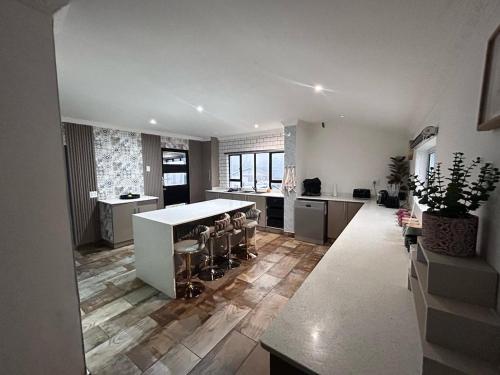 a large kitchen with a counter and stools at Tranquil stay and venue in the heart of Ixopo in Ixopo