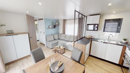 kuchnia i salon ze stołem i kanapą w obiekcie MH263 3 chambres et 2 salles de bain dans camping 4 étoiles w mieście Saint-Julien-en-Born