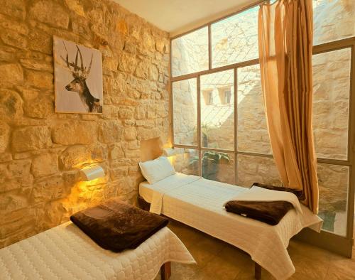 a bedroom with two beds and a window at Dana Sunset Village Hotel in Dana