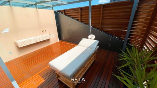 a balcony with a bench on a wooden floor at Setai Aquamaris by Setai Apartaments in João Pessoa