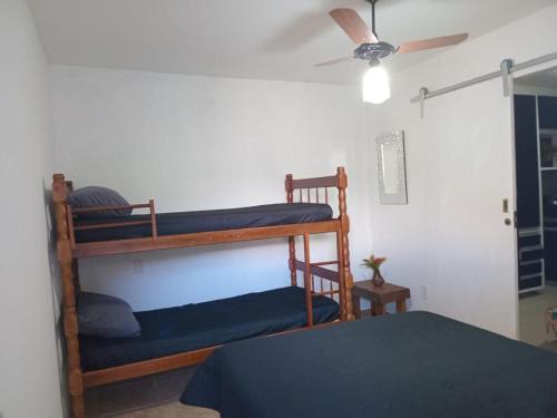 um quarto com 2 beliches e uma ventoinha de tecto em Casa completa em cabo frio em Cabo Frio