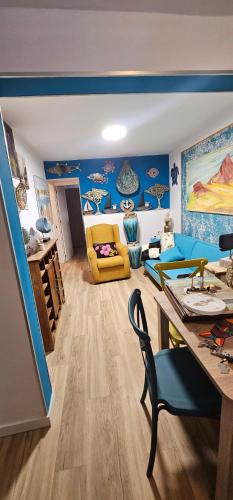 - un salon avec des murs bleus et un canapé jaune dans l'établissement Descanso cerca del mar, à Las Galletas