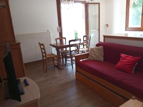 un salon avec un canapé rouge et une table dans l'établissement Chez Marinette, à Saint-Jean-Saint-Nicolas