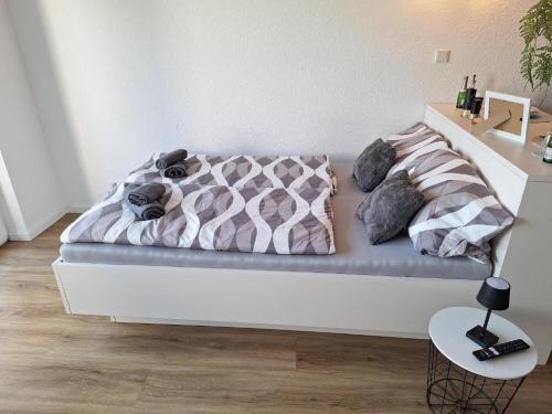 Cama en habitación blanca con marco de cama en Arpartement Deluxe 2 mit balkon prüm, en Weinsheim