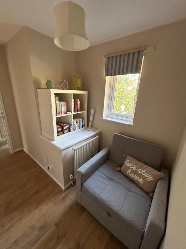 a living room with a couch and a book shelf at Cosy Family Home in Lovely Stony Stratford in Stony Stratford