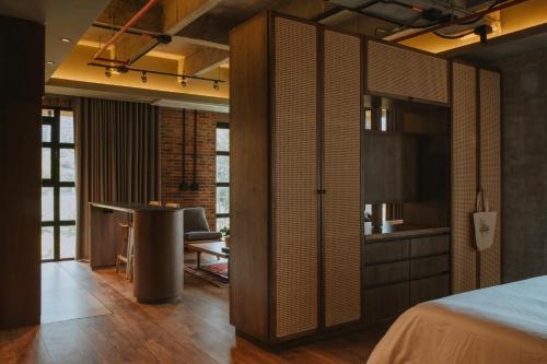 ein Schlafzimmer mit Bett und Schreibtisch und eine Küche in der Unterkunft Hotel dieztreintayseis in Medellín