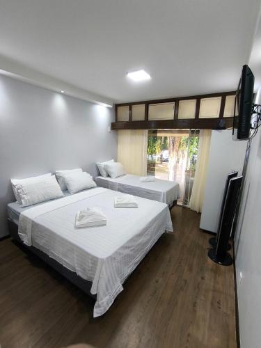 a bedroom with two beds and a flat screen tv at Apartamento aconchegante na Asa Norte in Brasilia