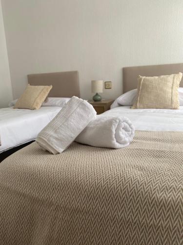 two beds with towels on top of them in a bedroom at Piso en el corazon de Las Torres de Cotillas in Las Torres de Cotillas