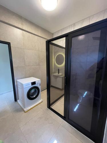 een badkamer met een wasmachine naast een raam bij Majestic Apartment 1 Tout lui Faut in Flora