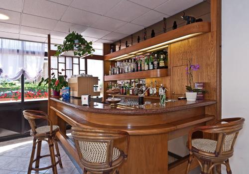 a bar in a restaurant with chairs around it at Hotel Prestige in Lido di Camaiore
