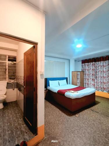 a bedroom with a bed and a toilet in it at Hotel Falcon View in Darjeeling