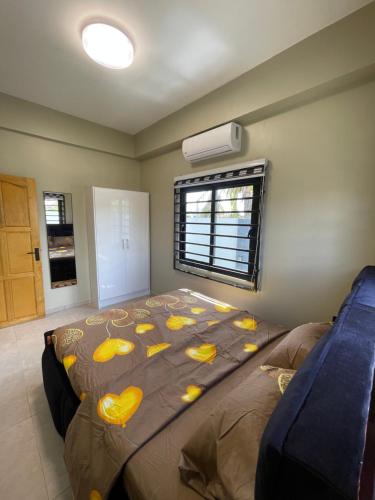 een slaapkamer met een bed met gele kussens erop bij Majestic Apartment 1 Tout lui Faut in Flora