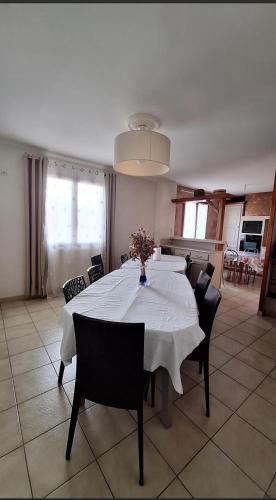 une table de salle à manger avec une nappe blanche dessus dans l'établissement DYNAMIQUE ET SPLENDIDE, à Bourgoin-Jallieu