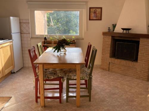 a kitchen with a wooden table with chairs and a fireplace at Casetta nel bosco di Valeria e Davide in Rocca Priora