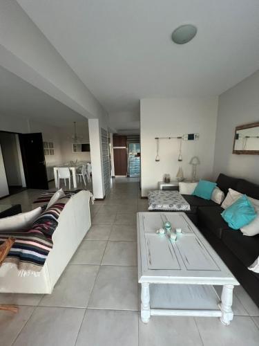 ein Wohnzimmer mit Sofa und Tisch in der Unterkunft Semipiso de Categoria con Vista al Mar in Monte Hermoso