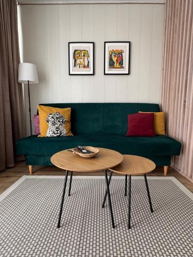 a living room with a green couch and a table at Feels like home in Visaginas