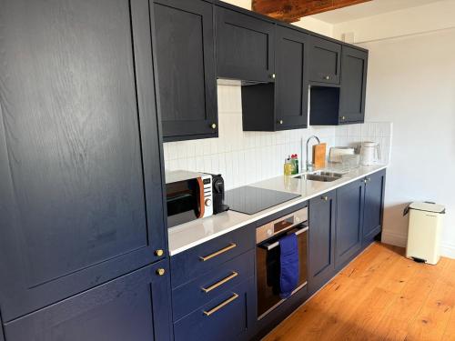 a kitchen with blue cabinets and a counter top at The Loft at 2 Bath Street in Bath