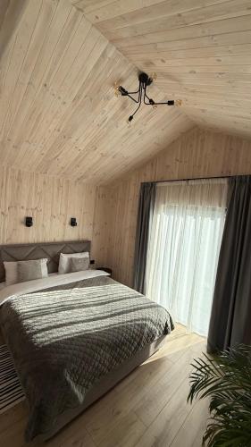 a bedroom with a bed and a ceiling with a window at ForRest будинок з чаном in Moshchun