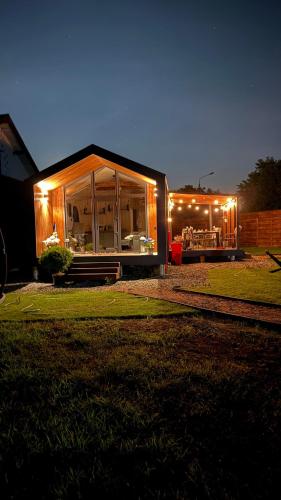 a small house with lights on it at night at ForRest будинок з чаном in Moshchun