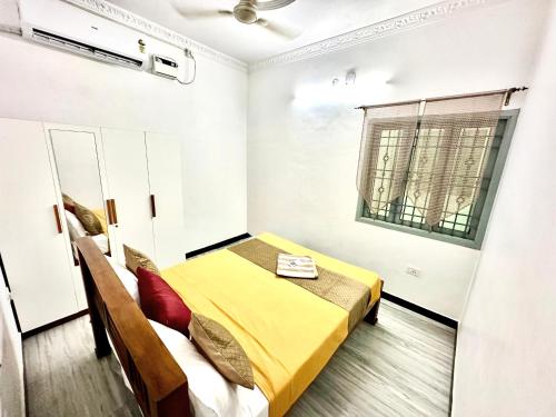 a small bedroom with a bed and a window at KPS homestay in Puducherry