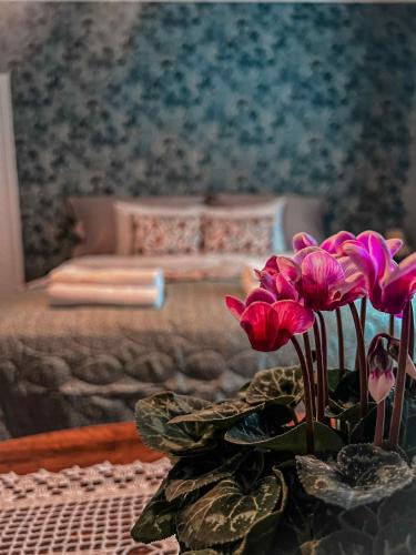 a bedroom with a bed and a table with pink flowers at Daisy's Home Vimmerby in Vimmerby