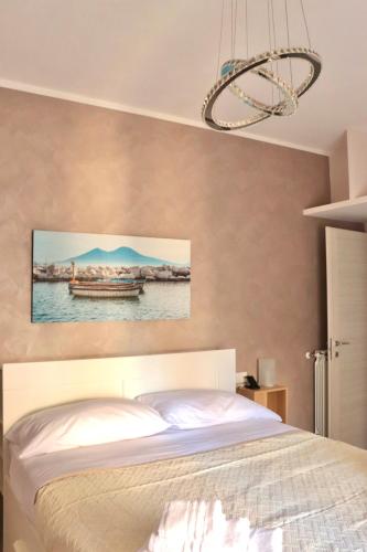 a bedroom with a bed and a painting on the wall at Parthenope Luxury Apartment in Naples