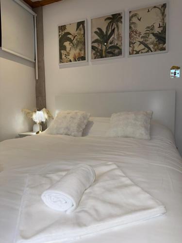 a white bed with a towel on top of it at The Garden Gate Cabin in Wallington