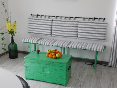 a table with a bowl of fruit on a green box at B&B Affittacamere La Dolce Mela in Francavilla di Sicilia