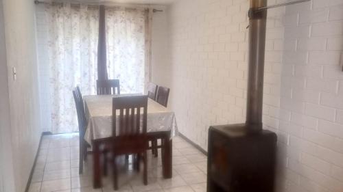 a dining room with a table and chairs and a stove at Casa hospedaje Annykita in Talca
