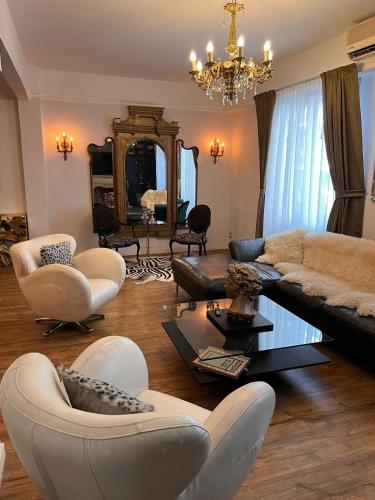 ein Wohnzimmer mit einem Sofa, Stühlen und einem Spiegel in der Unterkunft Recoleta Luxury Getaway Retreat Condo in Buenos Aires