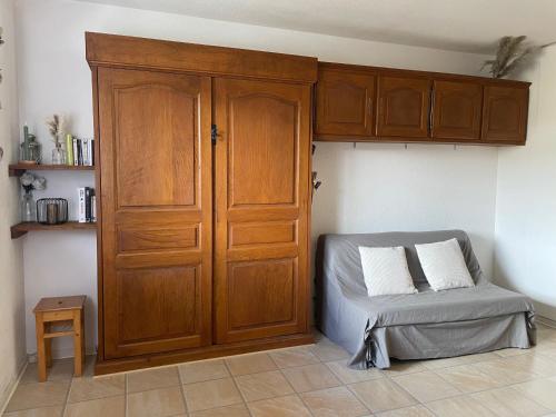 un lit dans une chambre avec une armoire en bois dans l'établissement Apparemment pied des pistes, à Saint-Lary-Soulan