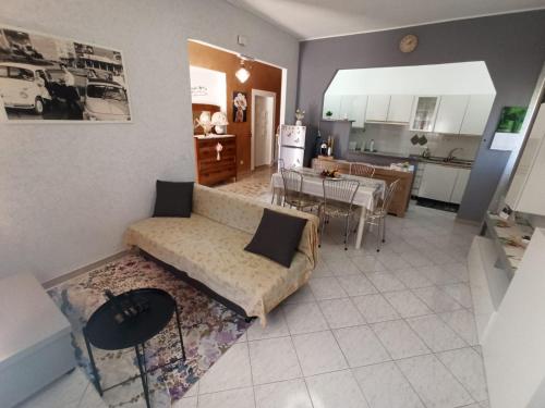 a living room with a couch and a kitchen at Magnolia Grande in Chieti