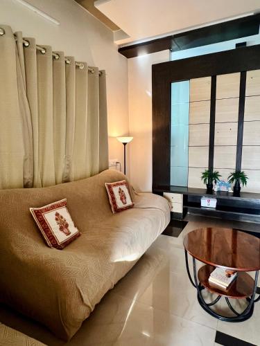 a living room with a couch and a table at Villa Sereno Belgaum in Belgaum