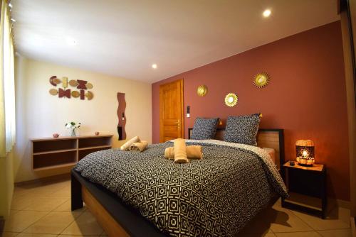 a bedroom with a large bed with brown walls at Le Courlis du Ried in Grussenheim