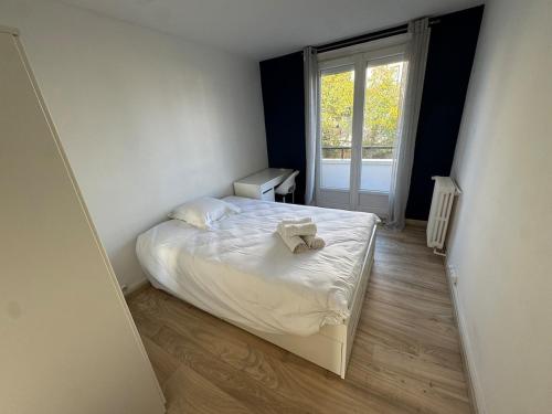 Un dormitorio pequeño con una cama y una ventana. en Grand appartement lumineux, en Beauvais