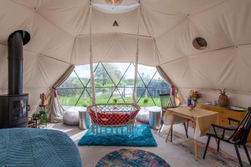 a room with a tent with a table and a chair at Wonderland in Henfield