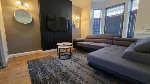 a living room with a couch and a tv at Large 5-Bed Home, Free Parking, Perfect for Groups in Nottingham