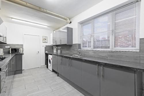 a large kitchen with a sink and a window at Large 5-Bed Home, Free Parking, Perfect for Groups in Nottingham