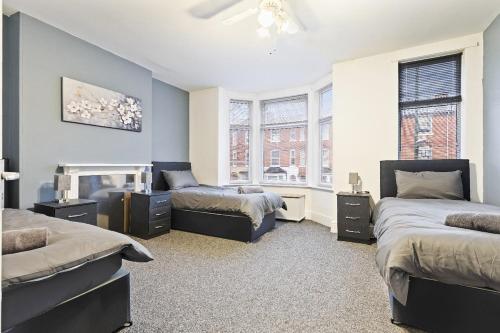a bedroom with two beds and a fireplace at Large 5-Bed Home, Free Parking, Perfect for Groups in Nottingham