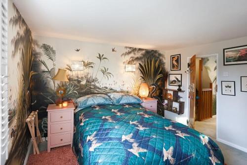 a bedroom with a bed with a blue comforter at Artists Hideaway in Cowfold
