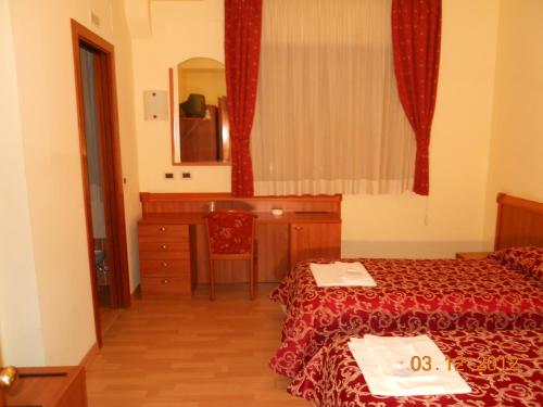 a bedroom with a bed and a dresser and a mirror at Hotel Val Di Sangro in Perano