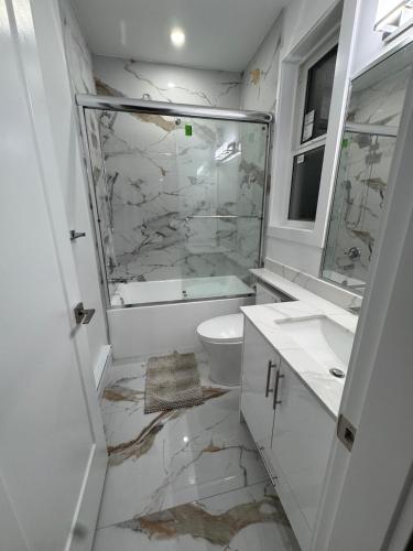 a white bathroom with a toilet and a sink at Brand new fully Private Garden Suite in Delta