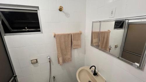 a bathroom with a toilet and a sink and a mirror at Conj Pajuçara 3 minutos da praia, 5 pessoas! in Maceió